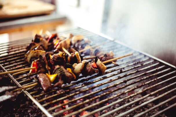 Grilled skewers with lean meat and colorful vegetables cooking on a barbecue grill, showcasing a healthy and balanced cookout option.