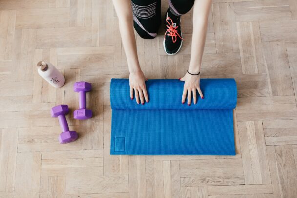 A calm woman practicing yoga in a sunlit studio, surrounded by peaceful ambiance—representing the mental, physical, and emotional benefits of yoga classes.