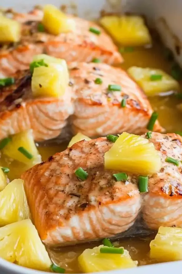 Baked Pineapple Salmon fillets topped with pineapple chunks and garnished with green onions in a sweet savory glaze.