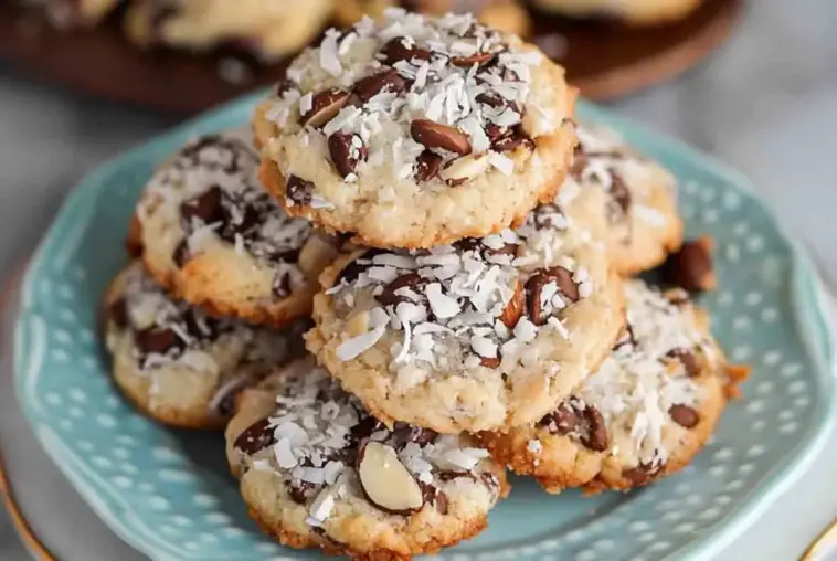 Plate of homemade 4 ingredient Almond Joy cookies with toasted coconut, melty chocolate chips, and crunchy almonds on top.