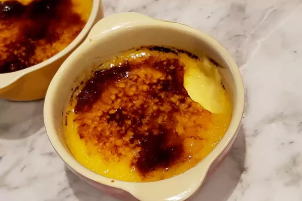 Overhead shot of crème brûlée in ramekins with caramelized sugar tops.