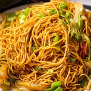 Close-up of homemade Panda Express Chow Mein with stir-fried noodles, cabbage, celery, and green onions served on a white plate