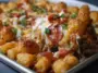 Golden brown tater tots baked over a layer of melted cheese, pizza sauce, and pepperoni, topped with chopped green onions and served hot from a casserole dish.