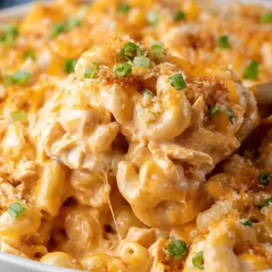 Close-up of creamy Buffalo Chicken Mac and Cheese topped with melted cheese, green onions, and crispy breadcrumbs in a white bowl.