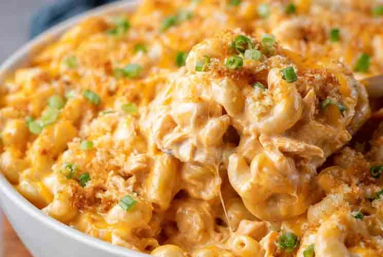 Bowl of baked Buffalo Chicken Mac and Cheese topped with golden breadcrumbs and chopped green onions, featuring creamy sauce and melted cheese.