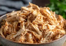 A bowl filled with juicy, tender Instant Pot shredded chicken, perfectly seasoned and ready to use in wraps, salads, tacos, or meal prep dishes.