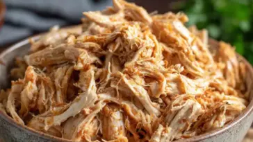 A bowl filled with juicy, tender Instant Pot shredded chicken, perfectly seasoned and ready to use in wraps, salads, tacos, or meal prep dishes.