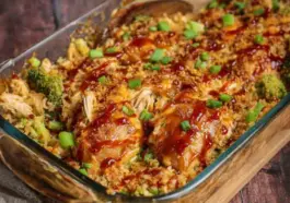 Glass baking dish filled with Teriyaki Chicken Casserole, showing shredded chicken, broccoli, rice, and a glossy teriyaki sauce, topped with chopped green onions.