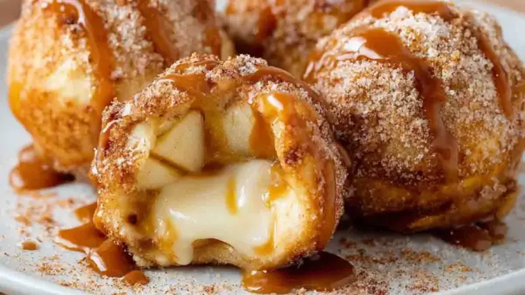 Caramel Apple Pie Bombs with gooey melted caramel center, soft apple filling, cinnamon sugar coating, and caramel drizzle on a white plate, close-up view
